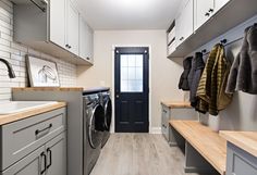 a washer and dryer in a small room with white cabinets on the walls