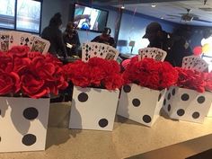 four white boxes with red flowers in them and cards on the table next to them