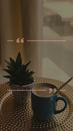 a cup of coffee sitting on top of a table next to a potted plant