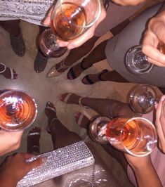 several people are holding wine glasses in a circle