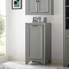 a bathroom with gray cabinets and white rugs