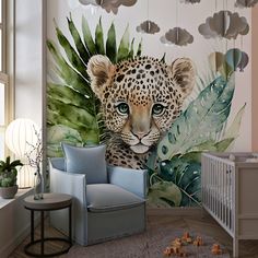 a baby's room with a leopard mural on the wall and a chair in front of it