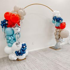 balloons and streamers are arranged in the shape of an arch