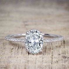 an oval cut diamond ring on a wooden surface