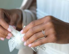 a close up of a person's hands holding something in their left hand and wearing a ring