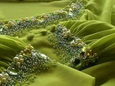 green fabric with pearls and beads on it