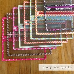 six different colored frames on a wooden table with the words crazy mom quilts written in them