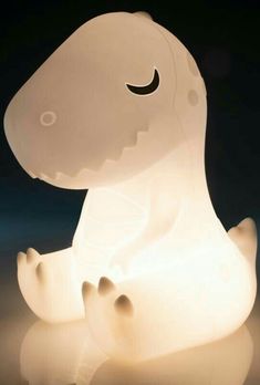 a light that looks like a dinosaur sitting on the ground with it's eyes closed