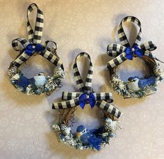 three wreaths with blue and white decorations on them