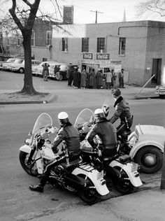 black and white photograph of three police officers on motorcycles