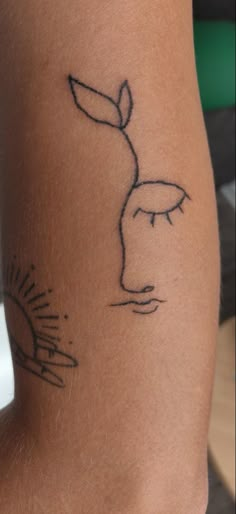 a woman's leg with a tattoo on it that has a hand holding a flower