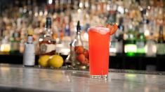 a red drink sitting on top of a bar