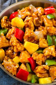 a pan filled with chicken, peppers and pineapples