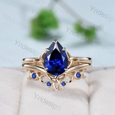 a gold ring with a blue stone in the center on top of a white cloth