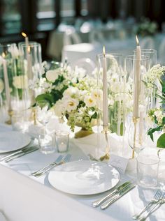 the table is set with candles, plates and napkins for an elegant wedding reception