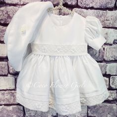 Beautiful white Christening and Baptism dress.    Dress and floppy hat set.  The 2 pieces match perfectly, the dress features puff ball shirt sleeves, satin bodice with a lace trim overlay along the waist and hem line.   Rear ties.  The floppy soft wide brim hat is adorned with a small centre rosebud. Available age 0 to 18 months. The size variations are for average age western baby body frame, for UK and USA this is the same.  Please simply order the age of the child if they are average body fr Solid Fitted Dress For First Communion, Fitted Short Sleeve Baptism Dress For First Communion, White Fitted Short Sleeve Baptism Dress, Fitted Baptism Dress For Wedding, Summer First Communion Fitted Dress, Elegant Fitted Baptism Dress For Church, Fitted Satin Dress For First Communion And Baptism, Champagne Flower Girl, Western Baby