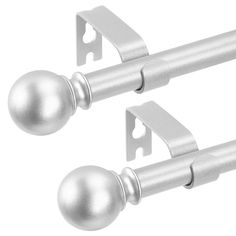 two silver door handles with metal balls on each side and one has a white background