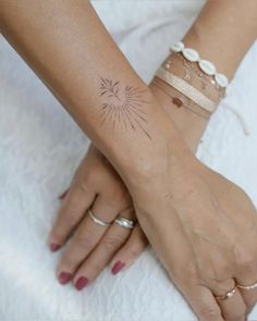 two women holding hands with tattoos on their arms and wrist, both wearing bracelets