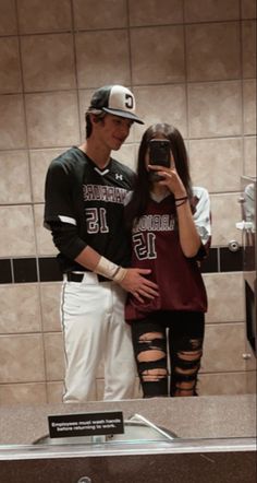 a man and woman are taking a selfie in the bathroom mirror with their cell phone