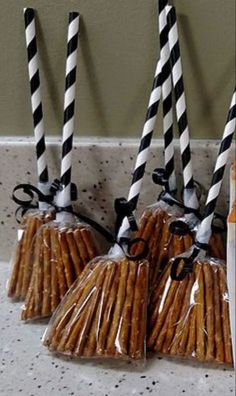 four black and white striped paper straws in plastic bags with twine ties on them