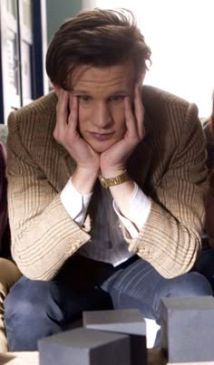 doctor who is sitting on the couch with his hands to his face