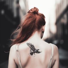 a woman with a bird tattoo on her back