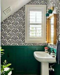 a white sink sitting under a bathroom window next to a green painted wall in a bathroom