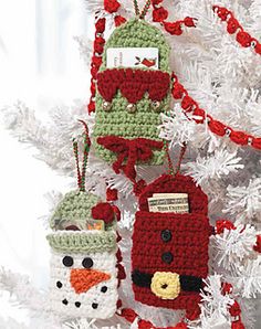 three crocheted christmas ornaments hanging from a white tree with red and green trim