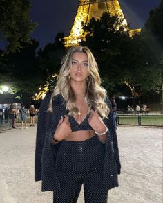 a woman standing in front of the eiffel tower with her hands on her hips