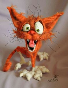 an orange knitted cat with its mouth open