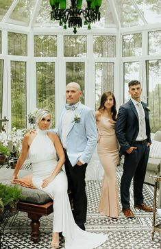 a group of people standing next to each other in front of a room with glass walls