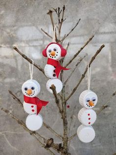 three snowman ornaments hanging from a tree