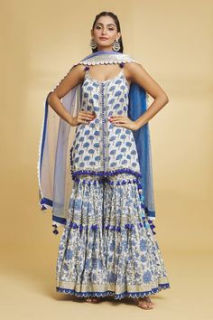 White and blue noodle strap sleeves singlet kurti with gul print all over and silver toned gota-sequin highlights detailing. Paired with a floral print gota striped and tassel embellished gharara and lace border, spluttered sequin embellished dupatta. - Aza Fashions Bohemian Fitted Sharara With Gota Work, Fitted Bohemian Sharara With Gota Work, Bohemian Sharara With Gota Work For Reception, Bohemian Floor-length Sharara With Gota Work, Bohemian Style Sharara With Cutdana, Bohemian Sharara With Dori Work For Eid, Bohemian Sharara With Cutdana For Reception, Bohemian Dori Work Sharara For Eid, Bohemian Sharara With Dupatta For Reception