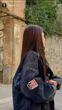 a woman standing on the street with her back turned to the camera