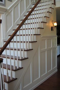 a white staircase with wooden handrails in a home's entryway area