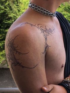 a man with a tattoo on his back and neck is holding onto a metal chain