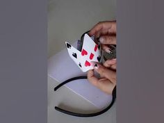 a person holding a card in their left hand and playing cards on the other side