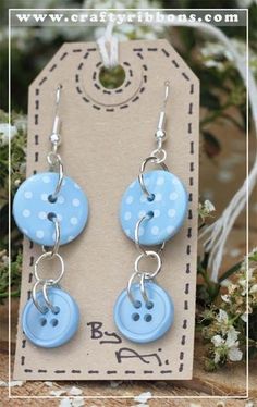 blue and white polka dot button earrings with silver earwires on a brown card