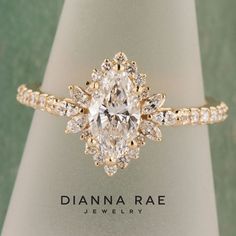 a diamond ring with an oval shaped center surrounded by smaller round diamonds