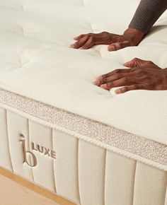 two hands on top of a white mattress