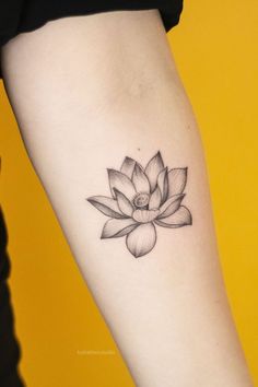 a black and white lotus tattoo on the left arm