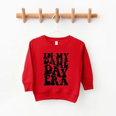 Looking for a cute sweatshirt for your kids? We have the perfect In My Game Day Era graphic sweatshirt addition to their closet! Also available in youth sweatshirts. Crew Neck Sweatshirt With Letter Print For Playtime, Red Letter Print Tops For Playtime, Red Letter Print Top For Playtime, Casual Red Sweatshirt For Game Day, Graphic Print Sweatshirt For Playtime In Fall, Red Letter Print Sweatshirt For Game Day, Red Hoodie Sweatshirt For Game Day, Sporty Red Sweatshirt For Game Day, Red Graphic Print Sweatshirt For Game Day