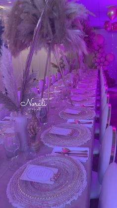 a long table set with place settings and centerpieces for a party or event