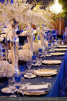 a long table is set with blue linens and white flowers