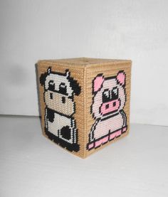 a small basket with a cow and pig design on the front, sitting on a white surface