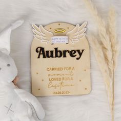 a teddy bear sitting next to a plaque that says aubrey