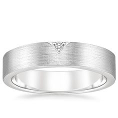 a white gold wedding ring with a diamond in the center and a satin finish on top