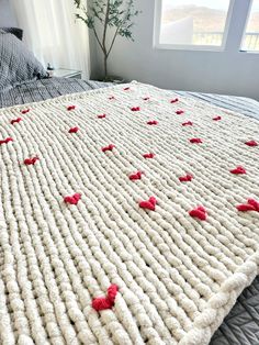 the bed is made up with red hearts on it