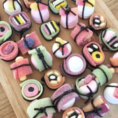 a wooden table topped with lots of different types of cookies and pastries on top of it