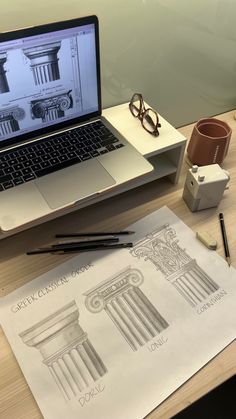 an open laptop computer sitting on top of a wooden desk next to a pair of glasses